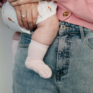 Baby wearing Mosey by Lamington organic cotton baby socks in blush pink.