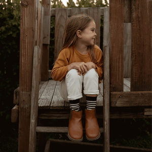 Child wearing Lamington merino crew socks in black with latte stripes made in New Zealand.
