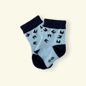 Mosey by Lamington merino baby socks in blue and navy with geometric pattern.