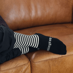 Woman wearing Lamington merino crew socks in black with latte stripes made in New Zealand.