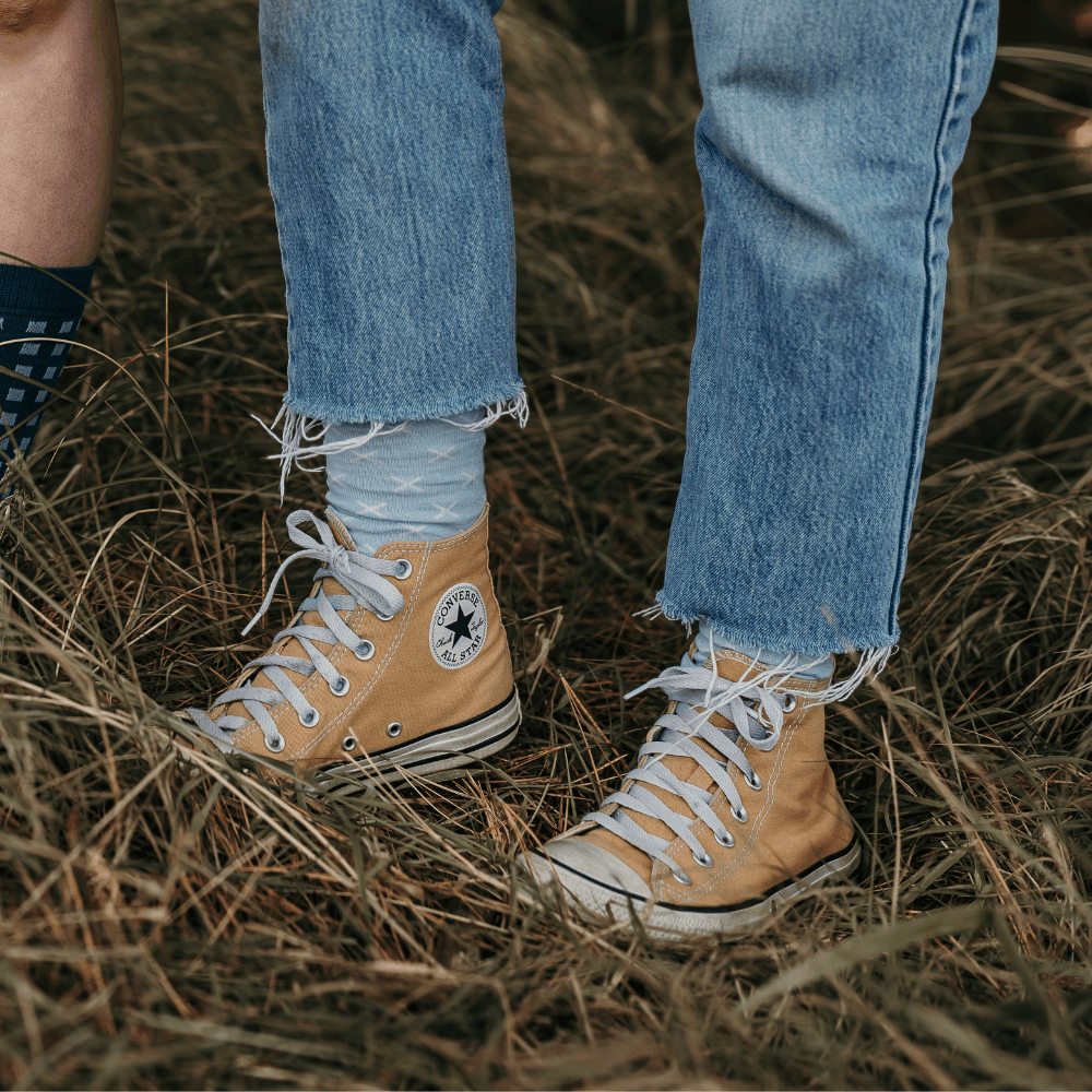 Woman wearing Lamington merino crew socks in light blue with white cross pattern made in New Zealand.