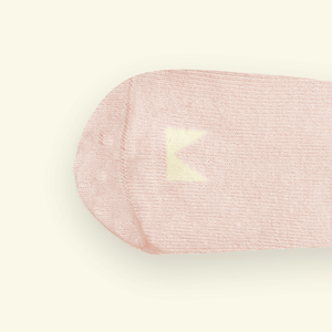 Close-up of Mosey by Lamington organic cotton baby socks in blush pink showing rib knit texture and logo detail
