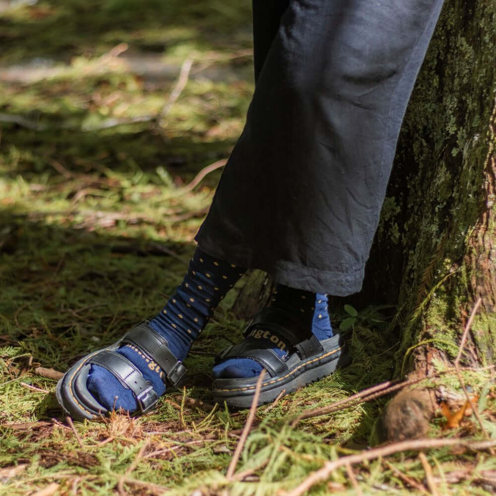 Woman wearing Lamington merino soft cuff crew socks in navy with mustard spots made in New Zealand.