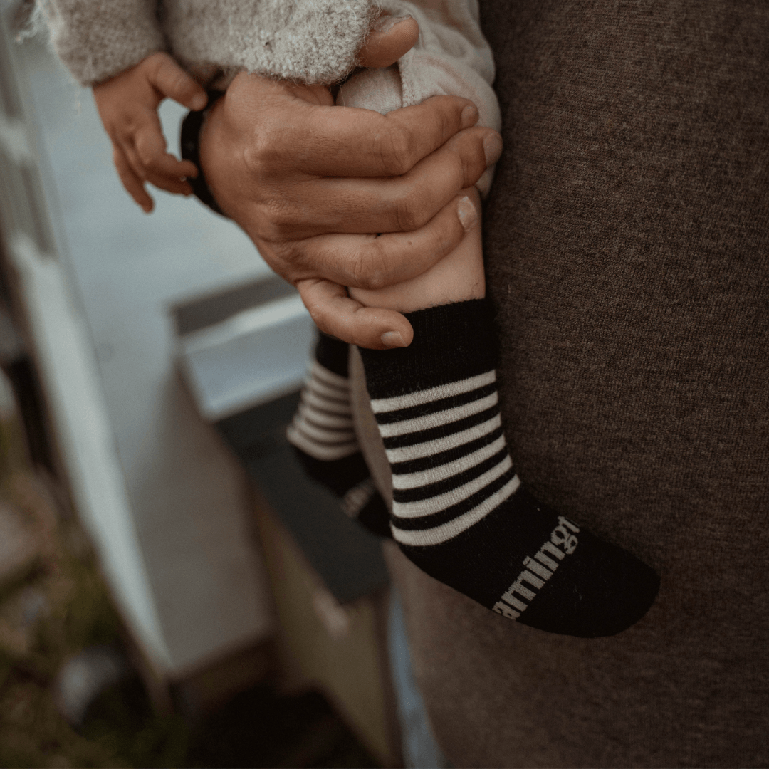 Baby wearing Lamington merino crew socks in black with latte stripes made in New Zealand.
