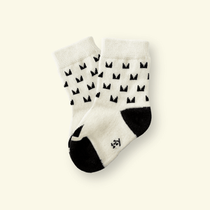 Mosey by Lamington merino baby socks in cream with black pattern.