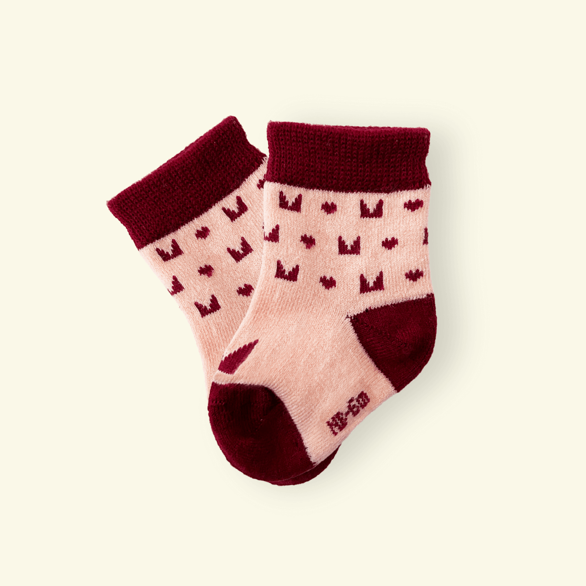 Mosey by Lamington merino baby socks in plum with geometric pattern.