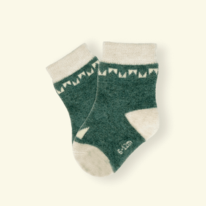 Mosey by Lamington merino baby socks in forest green with cream geometric pattern.