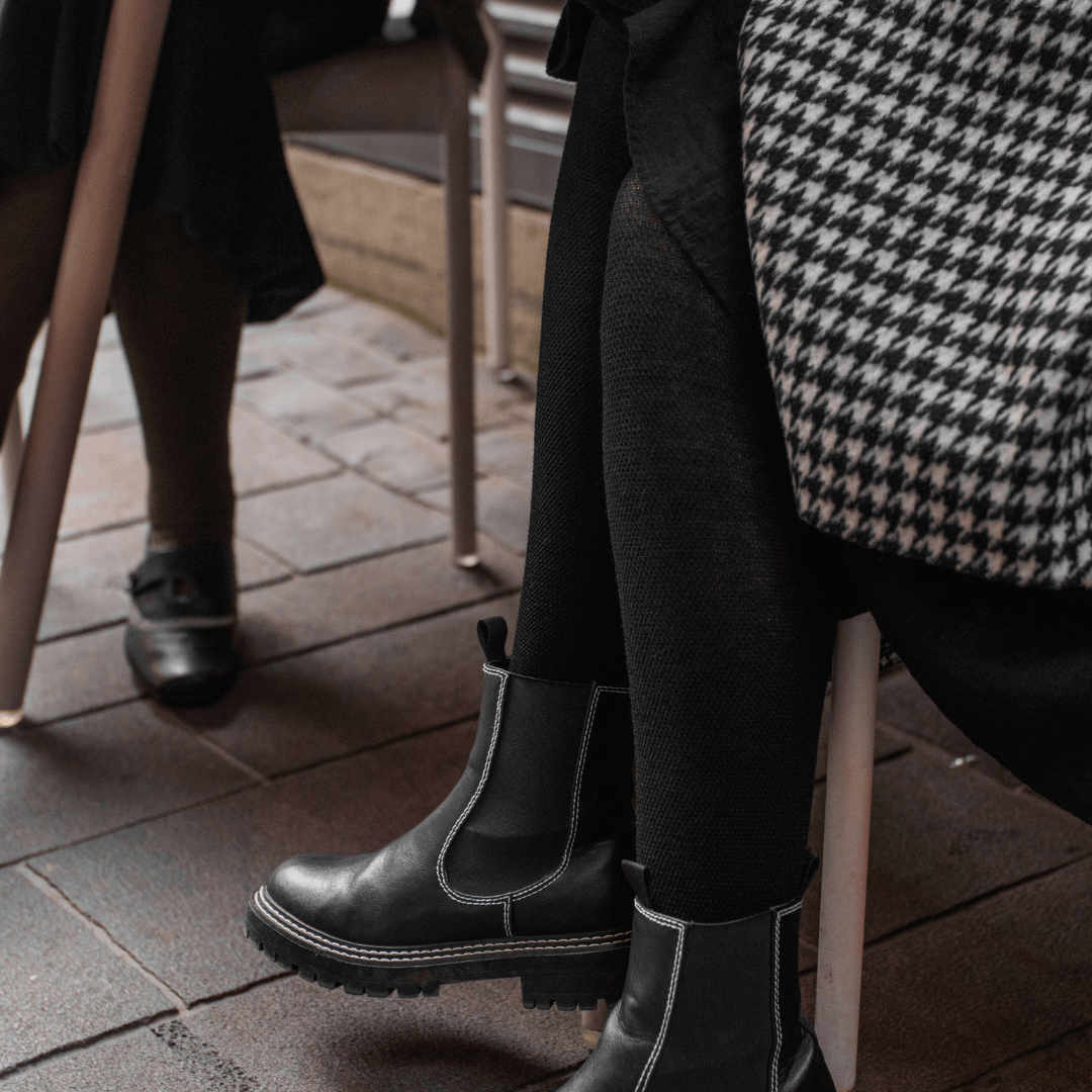 Woman wearing Mosey by Lamington women's merino textured knit tights in black.